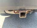 A rusty hitch receiver attached to the rear of a 2013 Ford Expedition