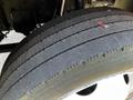 Close-up of a worn tire on a 2016 Isuzu NPR showing visible tread wear and some debris on the surface