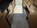 Interior view of a 2009 Morgan Olson Workhorse W62 featuring wooden storage cabinets and a metal floor in a work vehicle layout