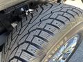 A close-up of a treaded tire on a 2015 Ford F-150 showcasing deep grooves designed for traction and winter driving performance