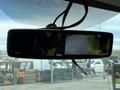 A rearview mirror displaying a digital screen with a view of the road behind a 2017 Chevrolet Express