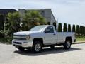 A silver 2016 Chevrolet Silverado 2500HD pickup truck with chrome accents and five-spoke wheels parked on a paved area
