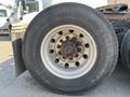 Close-up of a large tire from a 2022 Freightliner Cascadia showing the tread pattern and rim with visible bolts