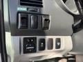 Interior dashboard controls of a 2015 Toyota Tacoma showing buttons for mirror adjustment and lights