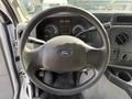 Steering wheel of a 2019 Ford Econoline featuring the Ford logo dashboard gauges and control knobs