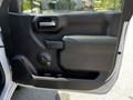 The interior door panel of a 2021 Chevrolet Silverado 1500 featuring a handle window control and storage compartment