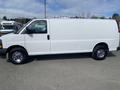 A 2022 GMC Savana van in white with a smooth exterior and chrome wheels displayed from the side