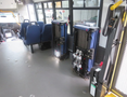 Interior of a 2020 Chevrolet Express showing blue seating on the left side and two professional-looking equipment storage units on the right side