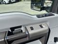 The image shows the interior door handle and controls of a 2016 Ford F-550 with a textured gray armrest and window controls