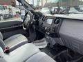 Interior of a 2015 Ford F-550 featuring gray fabric seats a center console and a dashboard with various controls and a display screen