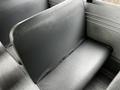 A grey vinyl seat inside a 2015 Spartan School Bus with a simple bench design and visible seatbelt attachments