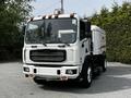 A 2012 Autocar Xpert street cleaning vehicle with a white body and large brush attachment at the front