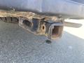 Close-up of the hitch receiver on a 2021 RAM 1500 showing a rusted exterior and an attached wiring harness