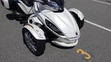 A white 2013 Can-Am Spyder featuring a motorcycle design with three wheels and a streamlined front end