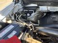 The engine compartment of a 2014 Ford F-150 showcasing the battery wiring and various engine components