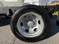 Close-up of a silver wheel of a 2017 Isuzu NQR with a Michelin tire mounted on it