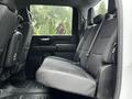 Rear seating area of a 2021 Chevrolet Silverado 3500HD featuring a spacious bench seat with grey upholstery and a minimalist interior design