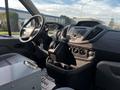 Front interior view of a 2017 Ford Transit showcasing the dashboard gear shift and console with various controls and compartments
