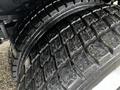 Close-up of a tire from a 2009 Ford F-550 showing deep treads and slight wear on the rubber surface