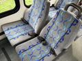 Interior seats of a 2009 Ford Econoline with gray fabric featuring blue wavy patterns and seatbelts installed
