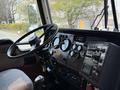 Interior view of a 1996 Kenworth T800 truck featuring a steering wheel and dashboard with various control gauges and switches