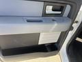 Interior door handle and panel of a 2012 Ford F-150 with a gray and black design including a cup holder and control buttons