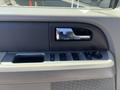 Interior door panel of a 2013 Ford Expedition featuring window controls and a door handle
