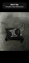 A black belt buckle featuring a design with a logo and a fence-like pattern with pointed ends