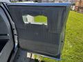 The open rear door of a 2013 Lincoln MKT featuring gray upholstery and a decorative panel with pleated detailing