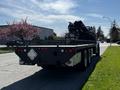 A 2012 Freightliner M2 112 truck with a flatbed and mounted equipment at the rear