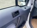 Interior door panel of a 2013 Ford Transit Connect featuring a door handle and a small control knob