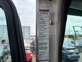 A 2013 Kenworth T370 truck driver's side door panel featuring a manufacturer information sticker detailing model and specifications
