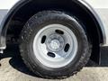 A close-up view of a 2017 Chevrolet Express tire featuring a rugged tread design and a silver wheel rim with six bolts