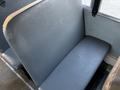 A gray, padded bus seat with a smooth surface and a wide backrest, designed for passenger comfort inside a vehicle