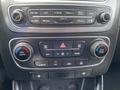 The dashboard controls of a 2015 Kia Sorento featuring radio, climate control, and navigation buttons