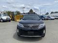 A black 2015 Kia Sorento with a sleek front design and a roof rack is shown prominently in the foreground