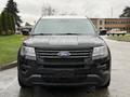 A black 2019 Ford Explorer facing forward with a prominent grille and headlights wet from rain