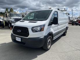 A 2019 Ford Transit van with a white exterior and black front grille positioned at an angle showing the driver's side