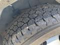 Close-up of a heavily worn tire from a 2020 Chevrolet Express showing deep treads and visible debris embedded in the rubber