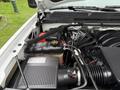 Close-up of the engine compartment of a 2015 GMC Sierra 1500 showing components like the air intake battery and coolant reservoir