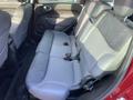 The image shows the rear seating area of a 2015 Fiat 500L featuring two rows of gray fabric seats with seatbelts