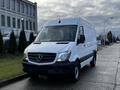 A white 2017 Mercedes-Benz Sprinter van is parked with its headlights on and a smooth front grille featuring the Mercedes emblem