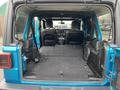 Interior of a 2020 Jeep Wrangler showing the rear cargo area with seats folded down and a clean black mat on the floor