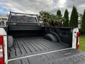 A 2020 Ford F-250 SD truck bed featuring a black rubber liner and a cargo management system at the rear