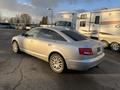 A 2006 Audi A6 in silver parked with a sleek design featuring prominent rear lights and multi-spoke alloy wheels