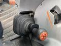 Close-up of the gear shift lever on a 2016 New Holland T475 tractor featuring a black rubber boot and an orange button on top