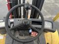 Overview of the steering wheel and control panel of a 2000 Hyster 120 forklift with levers and gauges visible