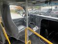 A 2017 Chevrolet Express interior featuring a driver's seat, steering wheel, and a protective divider made of clear plastic