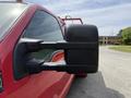 A red 2013 Ford F-550 with a side mirror prominently displayed in the foreground