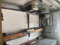 Interior of a Morgan Olson Workhorse W42 with a work table and electrical panel visible along with a whiteboard and various storage elements